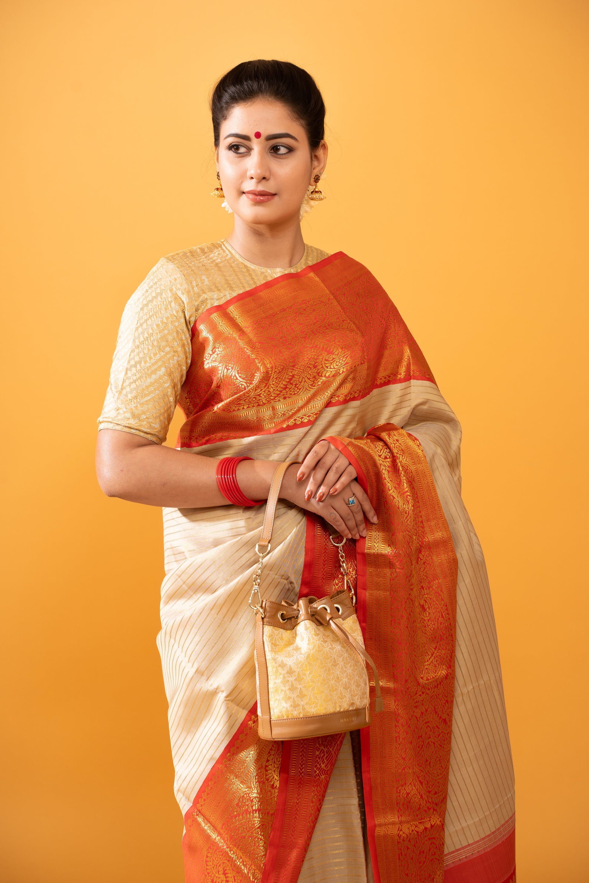 Traditional model showcasing the elegant Kanchi Tissue Potli Bag, adorned with intricate weaving, embodying timeless craftsmanship and cultural heritage
